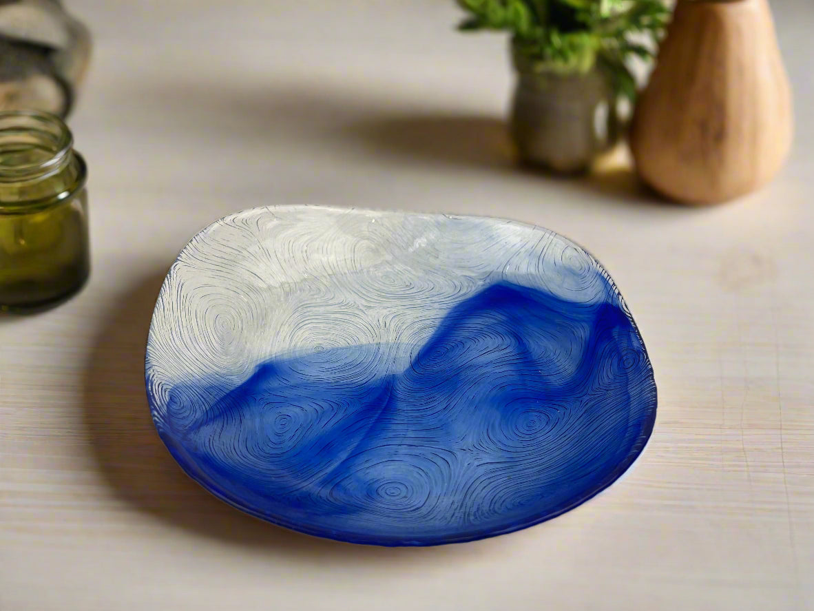 A blue and silver swirl pattern glass bowl on a table, part of a set of six.