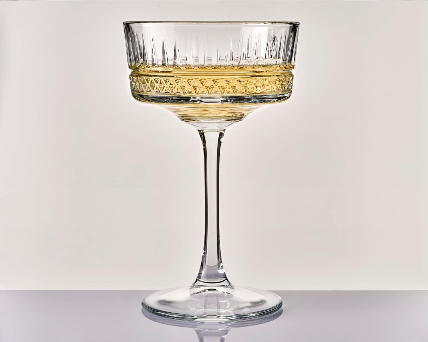 Set of four clear glass cocktail glasses on a white background
