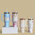 Four floral-themed tumblers with handles 
