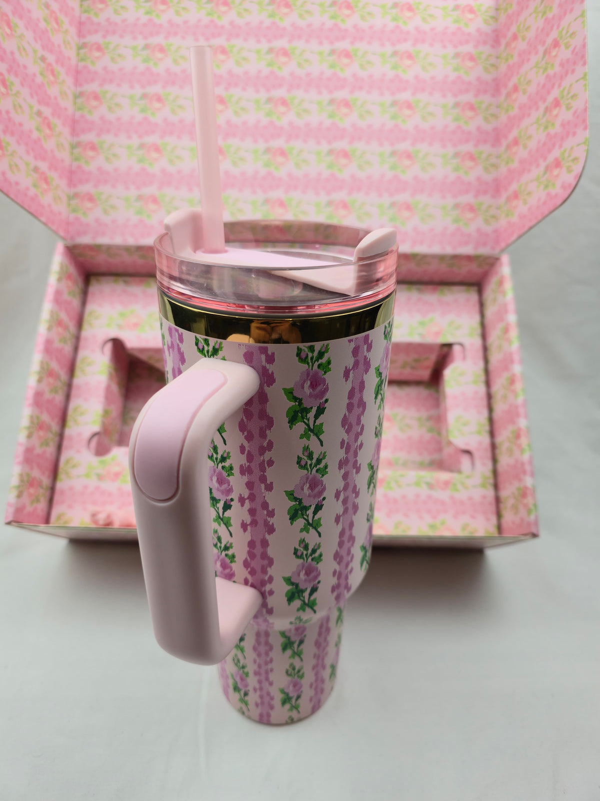 Pink floral-patterned tumbler with a handle
