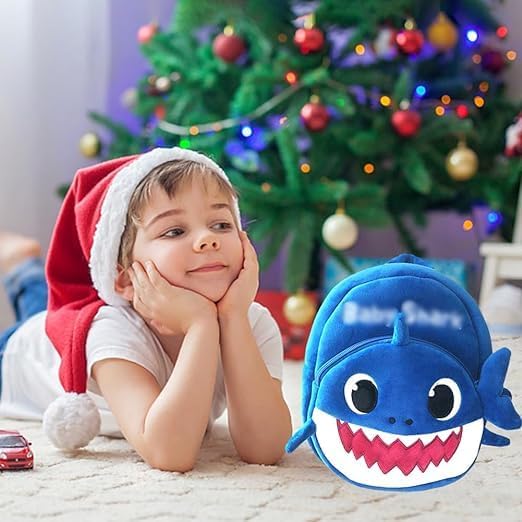 Child wearing a Santa hat with a Baby Shark plush toy 