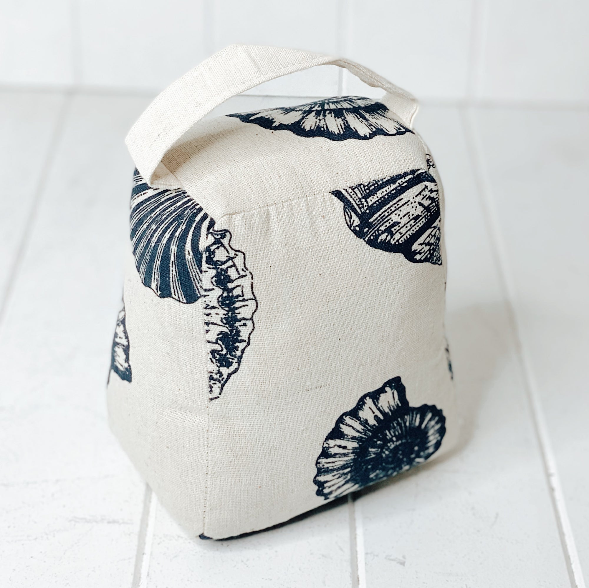 Secure and add a touch of coastal style to your doorway with our lovely Nautical Door Stop. This doorstop is the perfect addition to any home décor style featuring blue shell artwork on neutral tones. 16x13x18cm. | Bliss Gifts & Homewares | Unit 8, 259 Princes Hwy Ulladulla | South Coast NSW | Online Retail Gift & Homeware Shopping | 0427795959, 44541523
